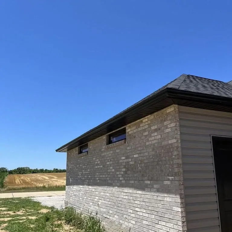 A dark gutter running along the eave of a brick building