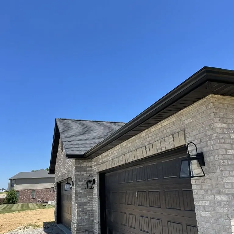 Dark gutters along the eaves of a gray brick garage